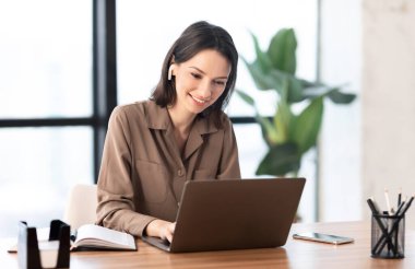 Portrait of happy woman listening to music using pc