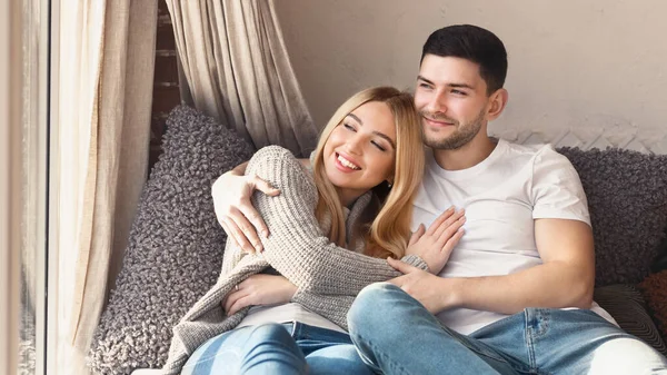 Preciosa pareja joven abrazándose en el sofá en casa — Foto de Stock