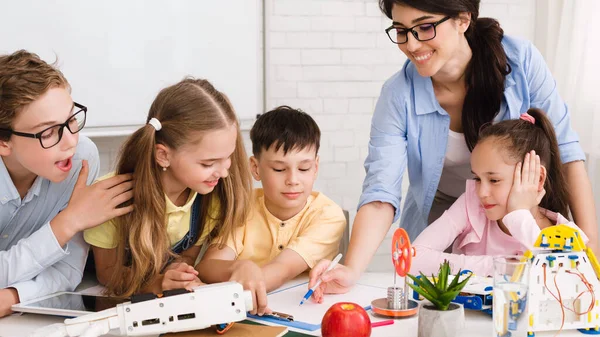 Stamonderwijs. Kinderen die robotles volgen, notities maken — Stockfoto