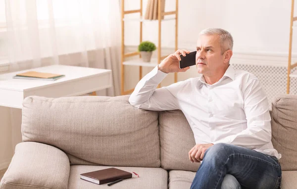 Homem sênior falando no telefone celular em sua casa — Fotografia de Stock