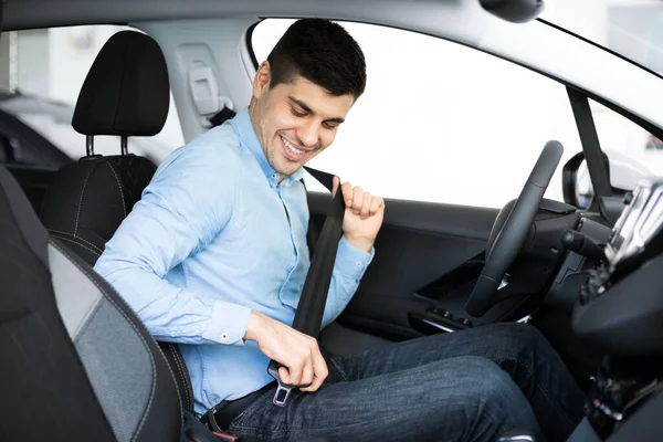 Guy zet op veiligheidsgordel zitten in de auto in Dealership — Stockfoto