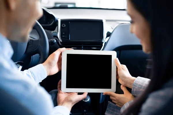 Пара с помощью планшета с пустым экраном, сидя в машине, вид сзади — стоковое фото