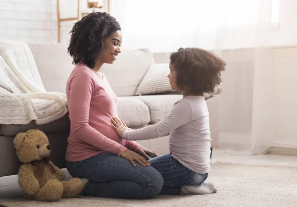 家で一緒に遊んでいる間に妊娠中のお母さん腹に触れる小さな娘 — ストック写真