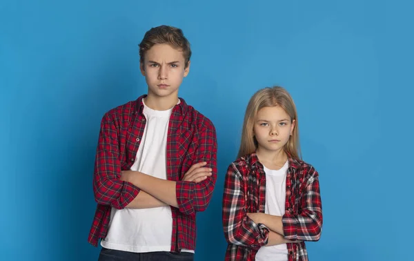 Siblings Conflicts. Frowning Little Brother And Sister Standing With Folded Arms — Stock Photo, Image