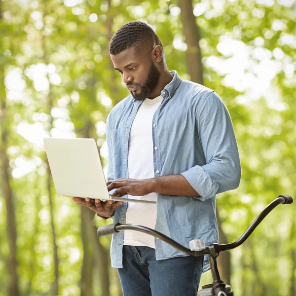 Rush Job. Focused afro businessman standing outdoors and using laptop — Zdjęcie stockowe