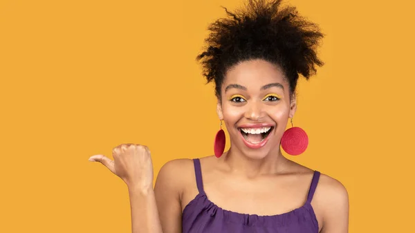 Aufgeregte schwarze Frau zeigt mit dem Finger auf freien Raum — Stockfoto