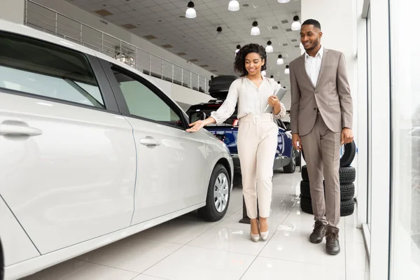 Empresário que escolhe o carro de luxo com o auto vendedor na sala de exposições da concessionária — Fotografia de Stock