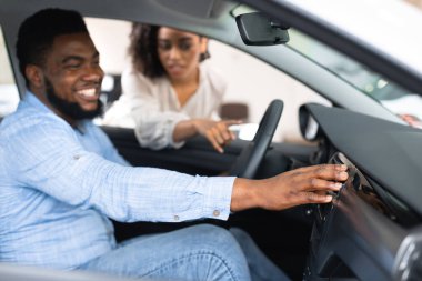 Family Couple Choosing New Car Testing Auto In Dealership Store