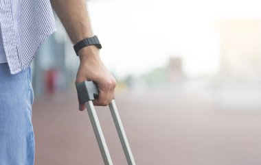Cropped Image Of Male Traveller With Suitcase Standing Outside Of Airport