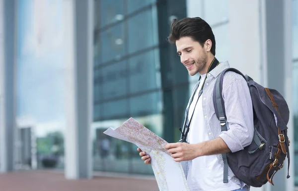 Smiling Man Tourist Standing Near Airport With City Map In Hands
