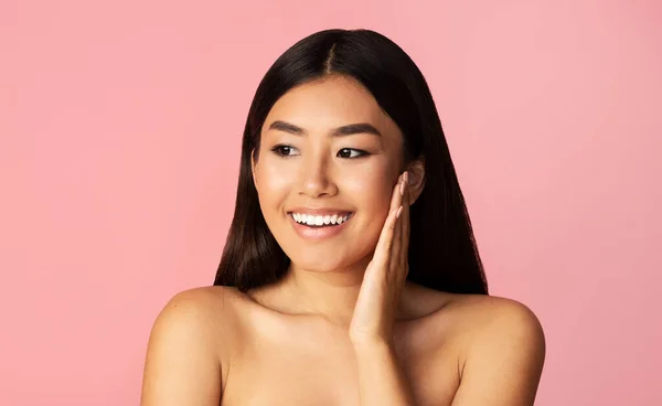Happy Asian Woman Touching Smooth Skin On Face, Studio Shot