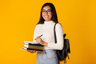 Asyalı Öğrenci Kız Kitap Tutuyor Sarı Arkaplan, Stüdyo