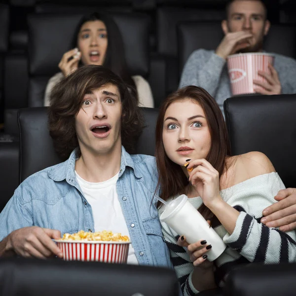 Leisure activity. Emotional young man with his girlfriend watching thriller in movie theater — Stock fotografie