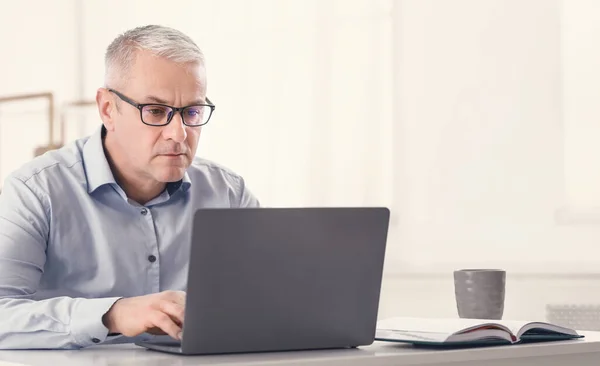 Schwerwiegender Senior benutzt Laptop zu Hause — Stockfoto