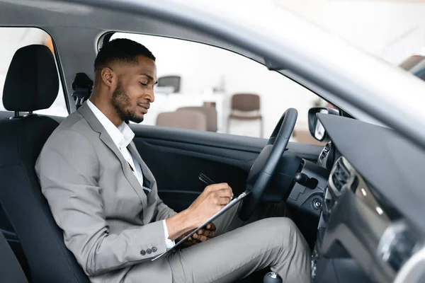 Professionell bilförsäljare sitter i automatisk anteckningar i Dealership — Stockfoto