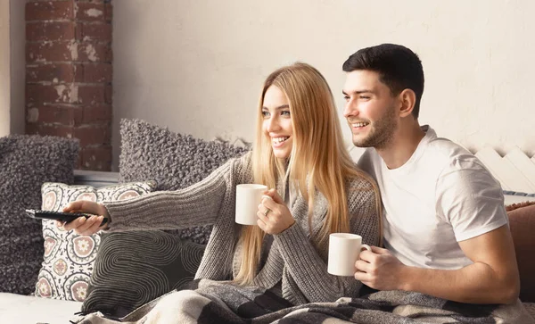 Adorável jovem casal assistindo TV juntos em casa — Fotografia de Stock