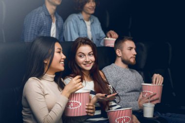 Mutlu arkadaşlar sinemada film izlerken eğleniyorlar.