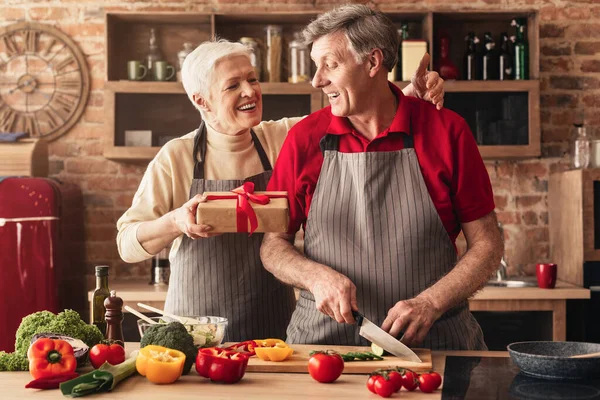 Kocanı doğum günüyle kutlayan, mutfakta hediye veren yaşlı bir kadın.