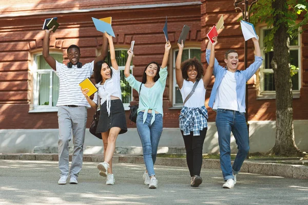 Retrato de estudantes universitários alegres andando ao ar livre depois de passar com sucesso exame — Fotografia de Stock