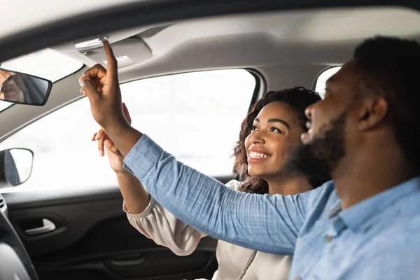 Couple Sitting In Car Pushing Buttons Testing Auto In Dealership — Stock Photo, Image