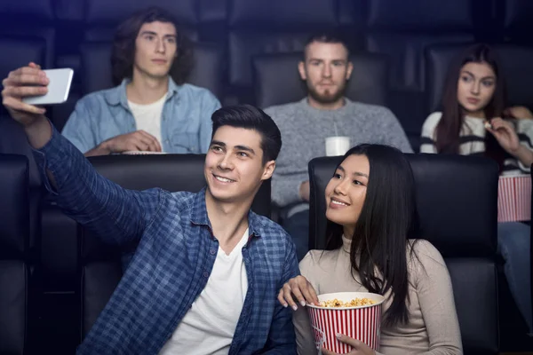 Recreação e lazer. Millennial casal tirando selfie em sua data de cinema no cinema — Fotografia de Stock