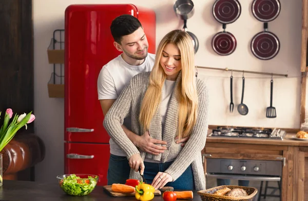 Šťastný mladý pár vaření zdravé jídlo společně v kuchyni — Stock fotografie