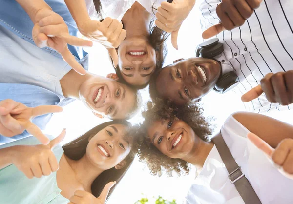 Adolescentes multiculturales alegres que están parados en círculo, mostrando gestos divertidos, ángulo bajo —  Fotos de Stock