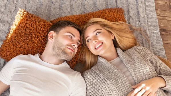 Sonriente pareja casada yaciendo juntos en el suelo en casa, por encima de la vista. Panorama — Foto de Stock