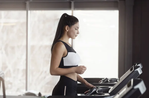 Beautiful Caucasian woman exercising on treadmill in gym, blank space — Stock Photo, Image