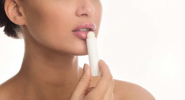 Close up of woman applying lip balm stick — Stok fotoğraf