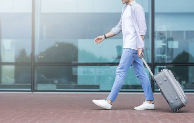 Going to terminal. Unrecognizable guy walking to airport with luggage