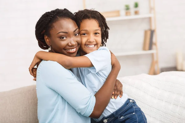 Negro madre e hija abrazándose en casa — Foto de Stock