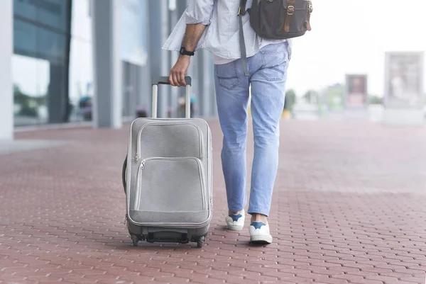 Camino al aeropuerto. Hombre irreconocible caminando con maleta y mochila al aire libre — Foto de Stock