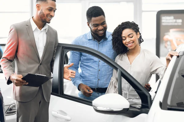 Car Selling Manager Showing Luxury Car To Buyers In Dealership — Φωτογραφία Αρχείου