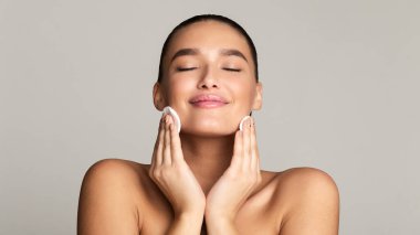 Girl removing make up with cotton pad