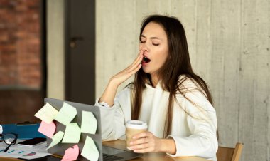 Exhausted young woman feeling sleepy with laptop