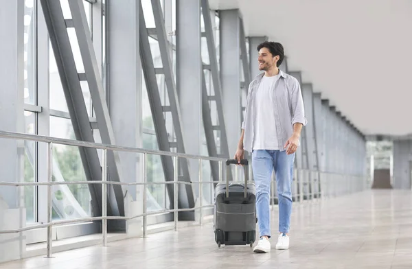 Start Of Journey. Handsome Man With Luggage Walking In Airport Corridor — Stockfoto