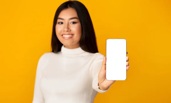 Girl Showing Phone Blank Screen Standing On Yellow Studio Background — Stok fotoğraf