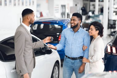 Afro Couple Taking Key From Manager In Car Rental Office