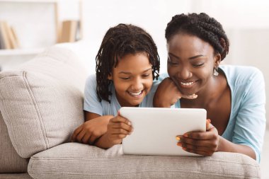 Black mother watching cartoons with her lovely daughter