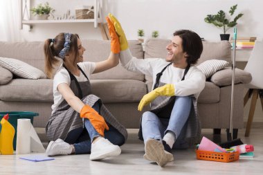 Happy Couple Giving High Five To Each Other After Cleaning Apartment clipart
