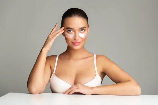 Young woman applying collagen under eye patches — Stok fotoğraf