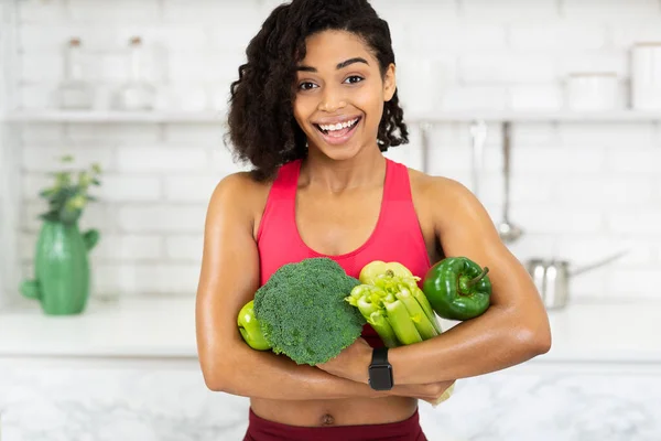 Счастливая молодая африканская девушка с зелеными овощами — стоковое фото