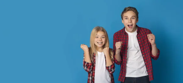 Bonita oferta. Alegre preadolescente hermanos gritando con emoción sobre fondo amarillo —  Fotos de Stock