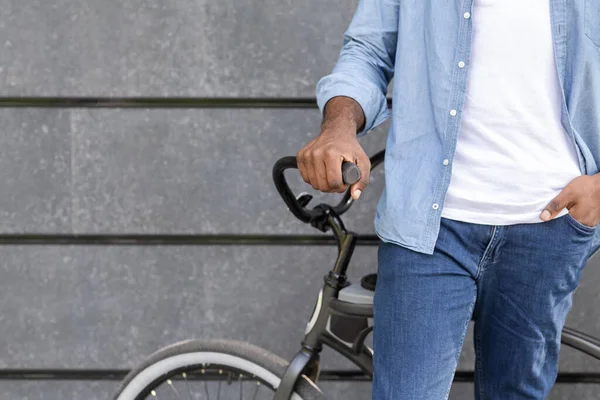 Fechar-se de homem africano irreconhecível em pé perto de sua bicicleta, segurando guidão — Fotografia de Stock