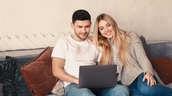 Ver filmes em casa. Bons cônjuges com laptop na sala de estar, panorama — Fotografia de Stock