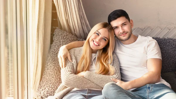 Mutlu milenyum eşleri evdeki kanepede sarılıyor, boşluğu kopyalıyor. — Stok fotoğraf
