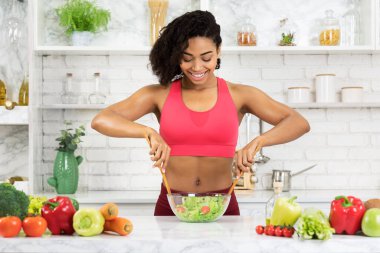 Güzel Afrikalı kız sebze salatası hazırlıyor.