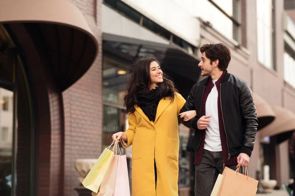 Pareja amorosa caminando llevando bolsas de papel de compras —  Fotos de Stock