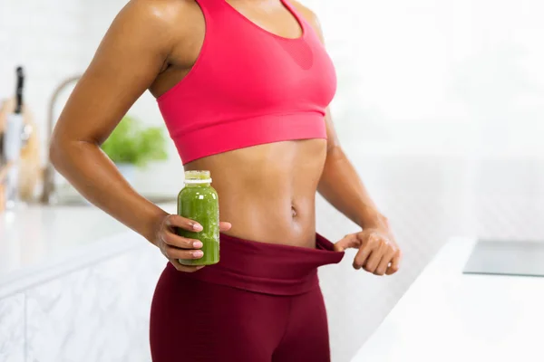 Apto Afro menina em tamanho grande calças segurando Detox Smoothie — Fotografia de Stock